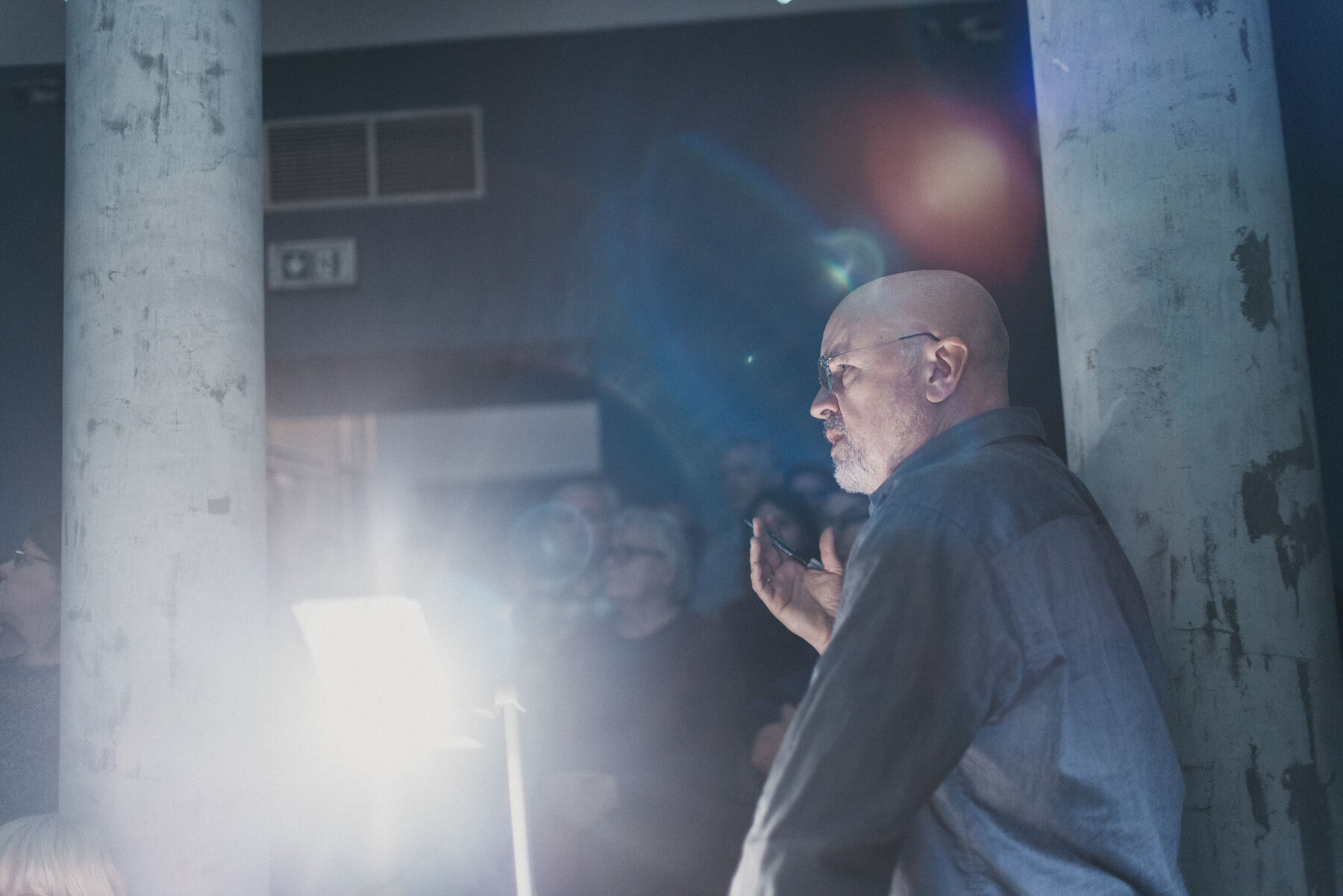 Artysta podczas prelekcji performatywnej w świetle analogowego projektora